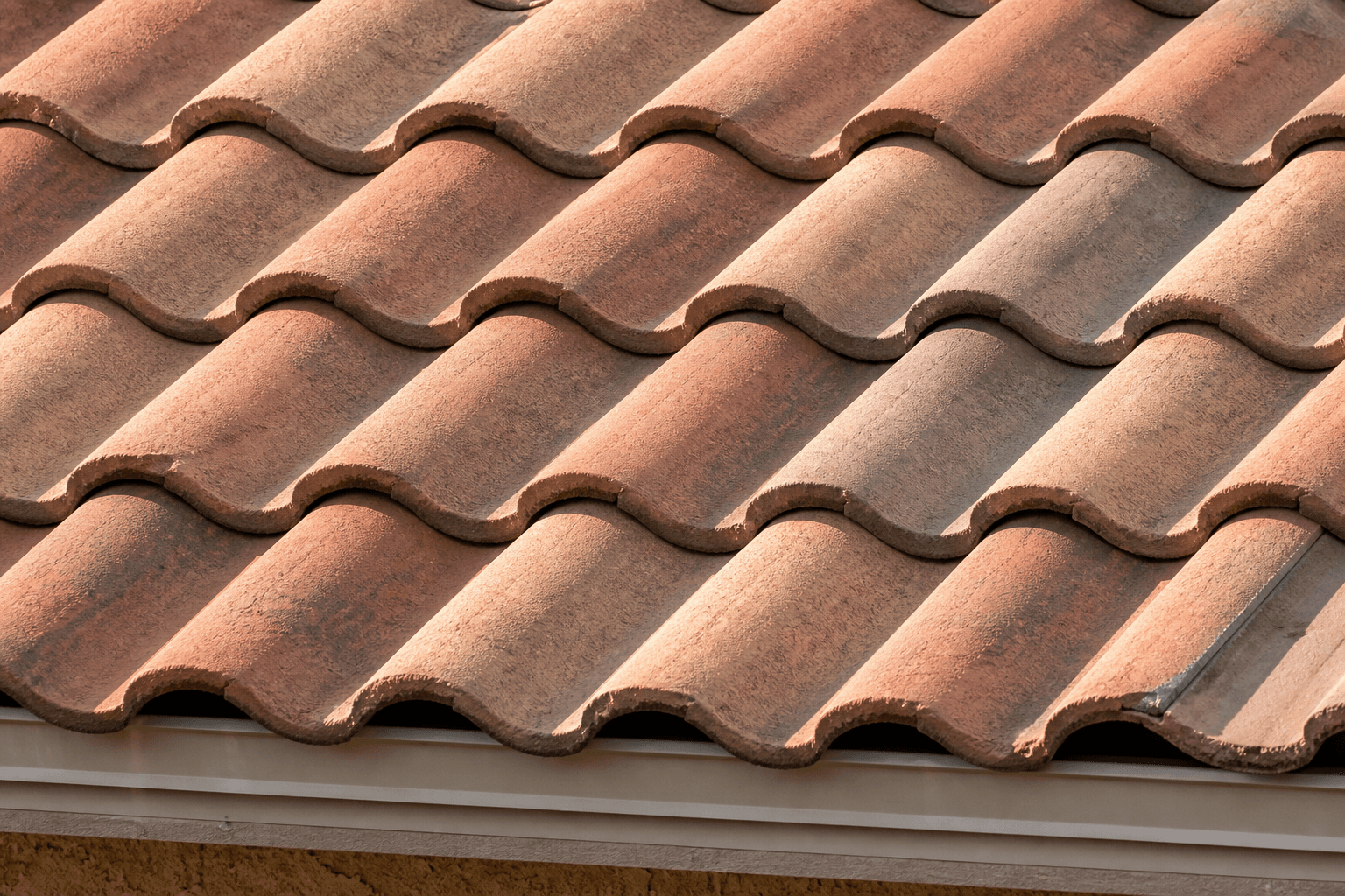 Close-up of warm earth-tone concrete s-tile roofing on an Anthem home, showing the rhythm of the tile rows and the warm color variation across the field.